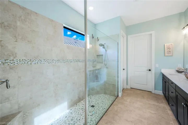 Bathroom featuring vanity, walk in shower, and tile patterned floors