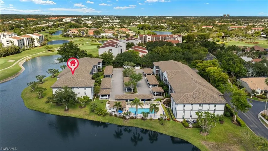 Aerial view of property's location featuring a golf course, a nearby body of water, a pool area, and nearby suburban area