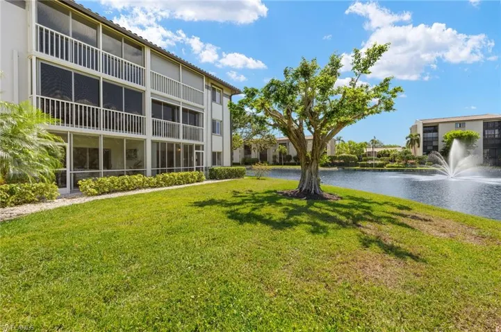 Surrounding community featuring a water view and a lawn