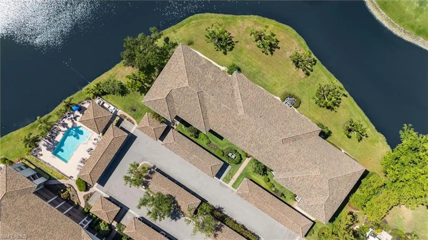 Drone / aerial view of a pool and a nearby body of water