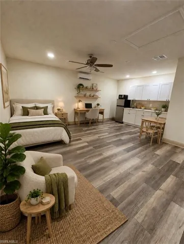 Wood-finish flooring throughout, white upper cabinetry, recessed lighting, and a ceiling fan with light fixture