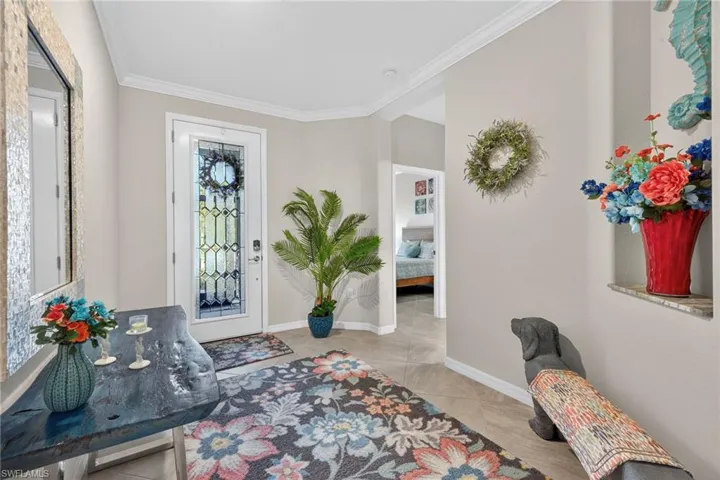 Entryway featuring ornamental molding and baseboards