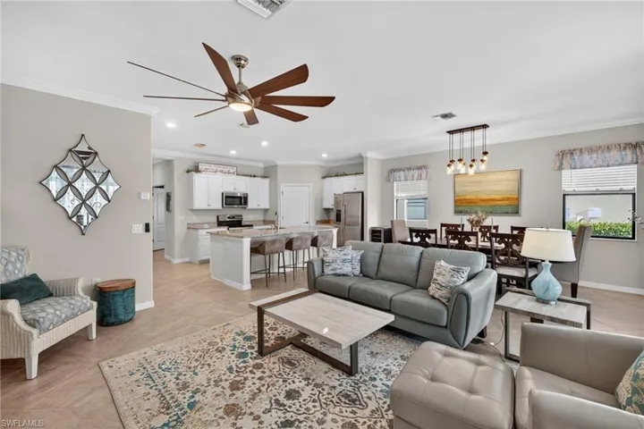 Living room featuring crown molding, a ceiling fan, and plenty of natural light