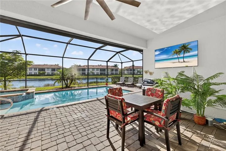 View of pool with a sunroom, glass enclosure, a pool with connected hot tub, and a patio
