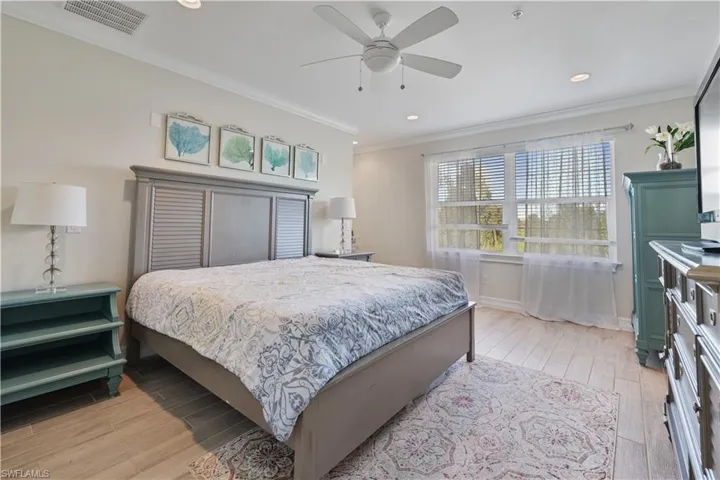Bedroom featuring light wood-style flooring, crown molding, a ceiling fan, and recessed lighting