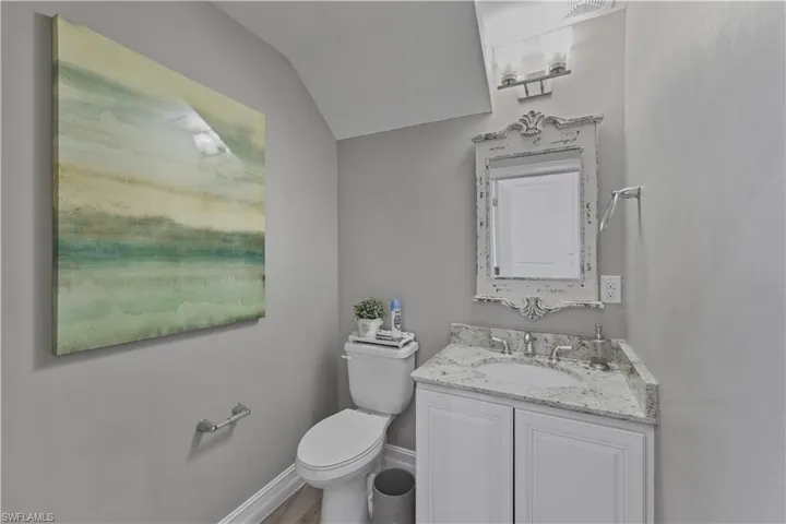 Bathroom featuring vanity and lofted ceiling