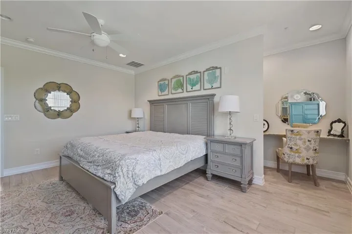 Bedroom featuring light wood-type flooring, ornamental molding, a ceiling fan, and recessed lighting