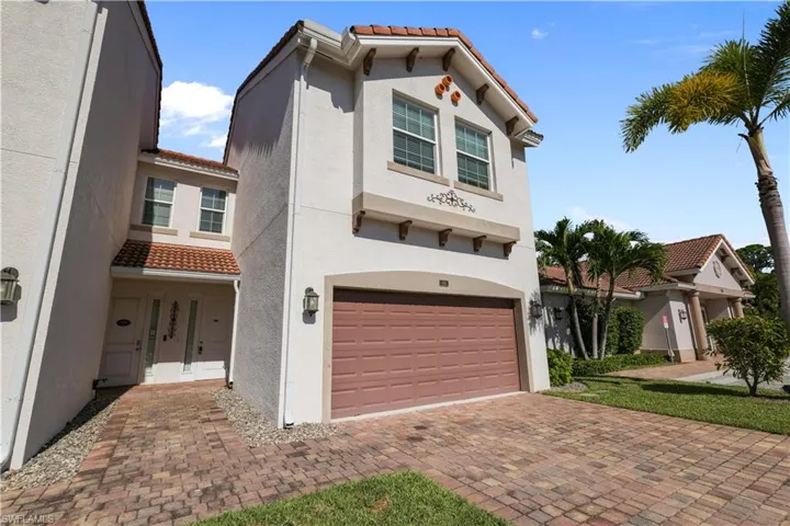 Mediterranean / spanish-style home with a tiled roof, stucco siding, a garage, and decorative driveway