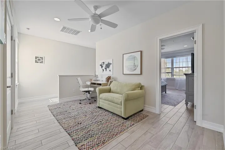 Living area with wood tiled floors, recessed lighting, ceiling fan, and a desk