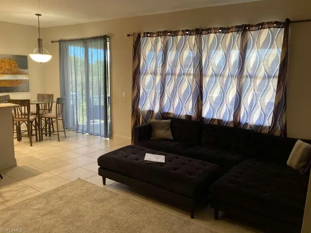 Open concept living space featuring tile flooring and a patio door with sheer curtains