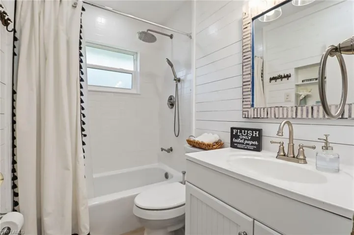 Bathroom featuring shower / bath combo with shower curtain and vanity