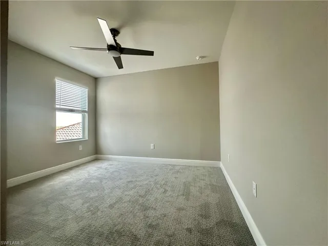 Unfurnished room featuring light colored carpet and ceiling fan