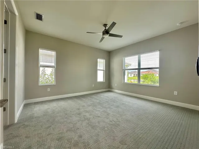 Carpeted empty room with baseboards and ceiling fan