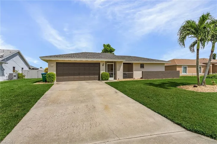 Single story home with a front yard and a garage