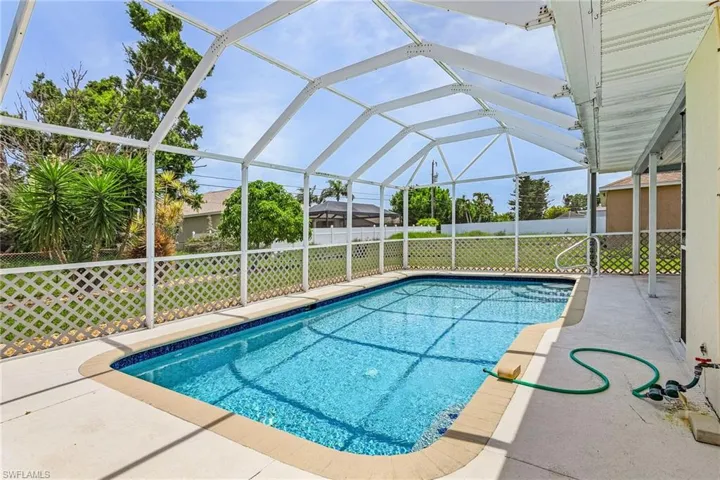 View of swimming pool featuring a yard, a patio area, and a lanai