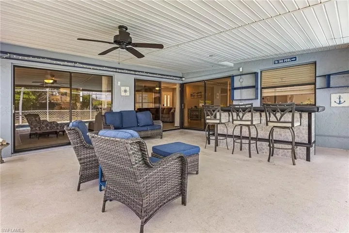 View of patio / terrace with outdoor lounge area, ceiling fan, and a bar