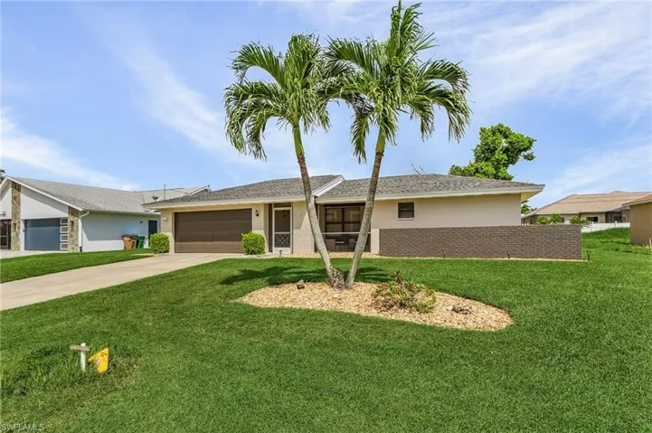 Ranch-style home with a garage and a front lawn