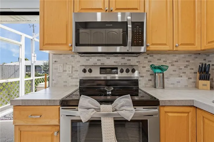 Kitchen featuring tasteful backsplash and appliances with stainless steel finishes