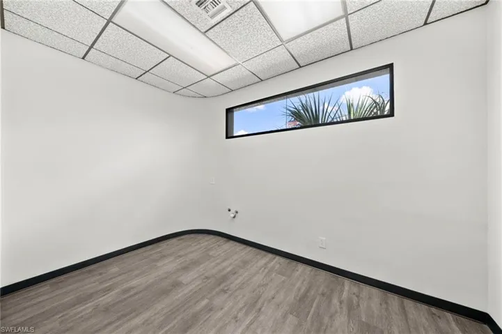Unfurnished room with a paneled ceiling and hardwood / wood-style floors