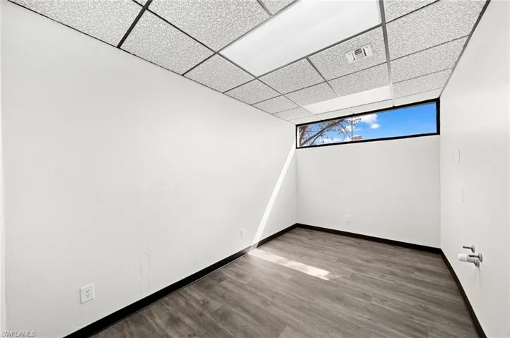 Spare room with hardwood / wood-style floors and a drop ceiling