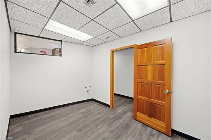 Basement featuring wood-type flooring and a paneled ceiling