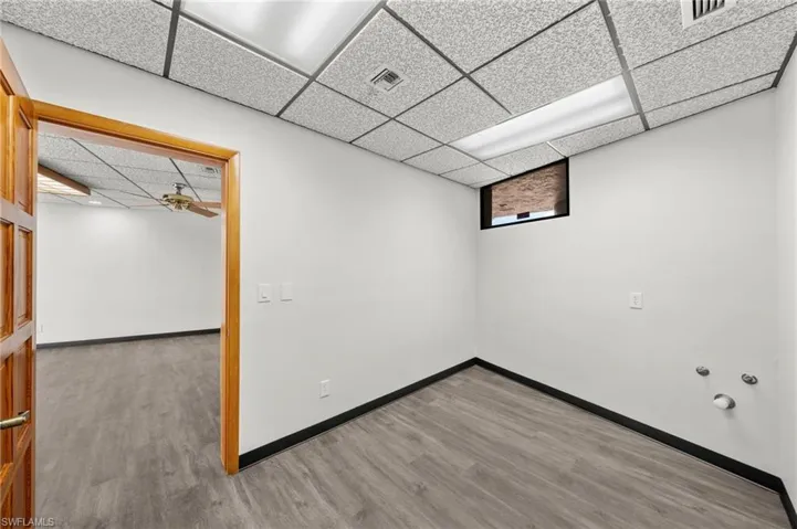 Unfurnished room with hardwood / wood-style floors, a paneled ceiling, and ceiling fan