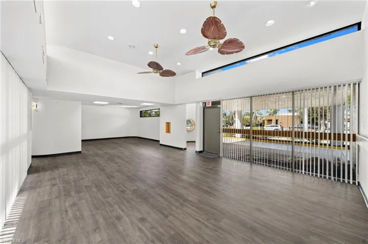 Unfurnished living room with dark hardwood / wood-style flooring and ceiling fan