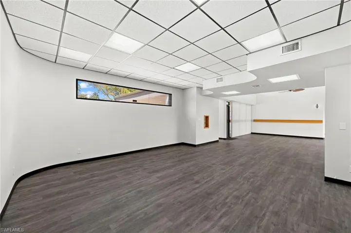 Unfurnished room featuring a paneled ceiling and dark hardwood / wood-style flooring