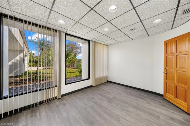 Spare room with a paneled ceiling and wood-type flooring
