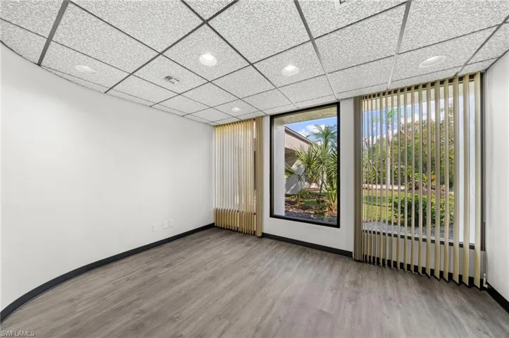 Unfurnished room featuring a drop ceiling and light wood-type flooring