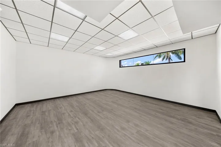 Basement with hardwood / wood-style floors and a paneled ceiling