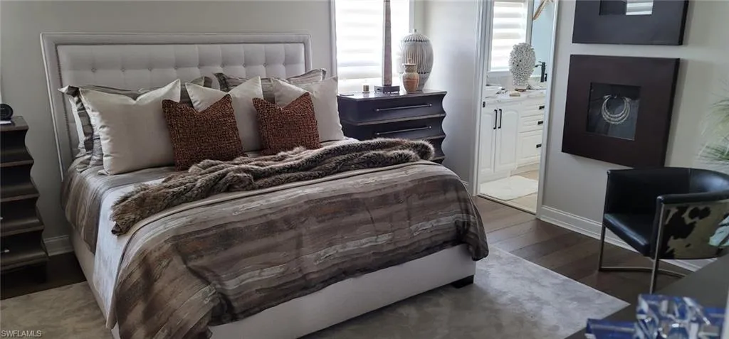 Bedroom with hardwood / wood-style flooring and ensuite bath