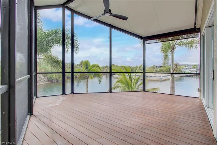 Unfurnished sunroom with a water view and ceiling fan