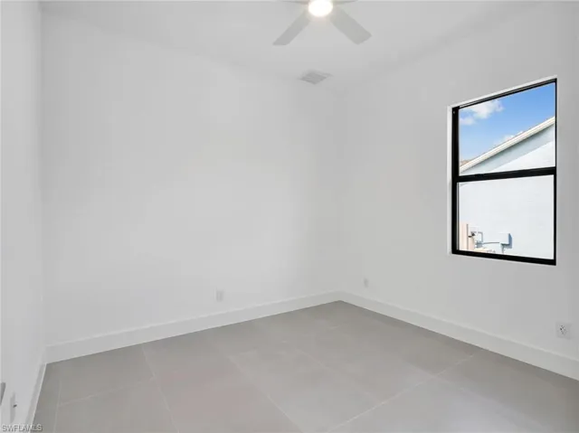 Unfurnished room featuring light tile patterned floors and a ceiling fan
