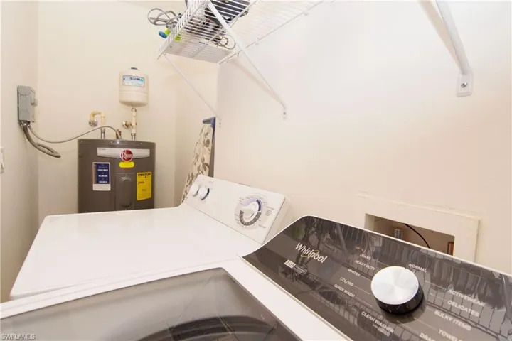 Laundry room in kitchen closet features on-site laundry with newer washing machine, clothes dryer and hot water tank.