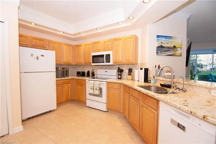 Kitchen features bright recessed lighting, crown molding, a large pantry, a washer and dryer closet, gleaming granite and coordinating backsplash, breakfast bar, a new dishwasher and microwave oven, and is fully stocked and outfitted turnkey!