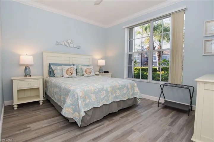 Spacious guest bedroom features newly installed luxury vinyl plank floors, ceiling fan, crown molding and a large walk in closet.