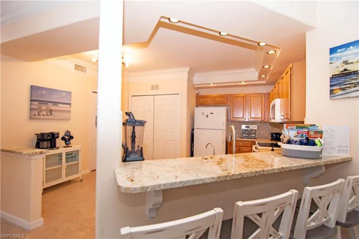 Kitchen features bright recessed lighting, crown molding, a large pantry, a washer and dryer closet, gleaming granite and coordinating backsplash, breakfast bar, a new dishwasher and microwave oven, and is fully stocked and outfitted turnkey!
