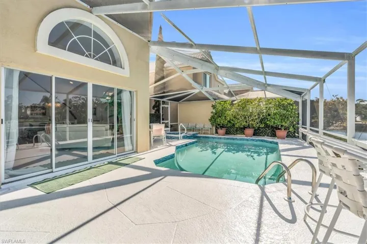 Outdoor pool with a sunroom, a patio area, and a lanai