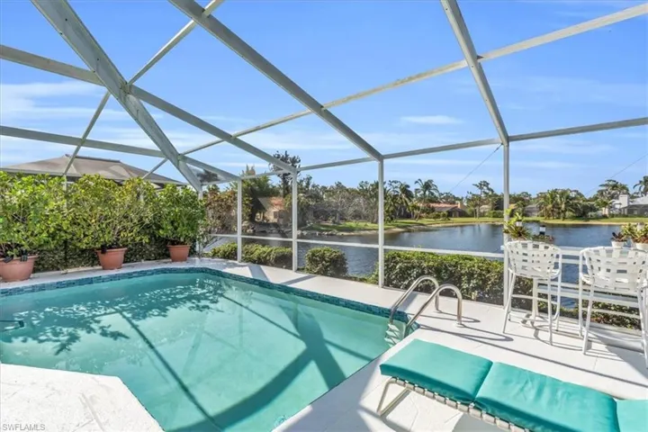 Swimming pool with a sunroom, glass enclosure, and a water view