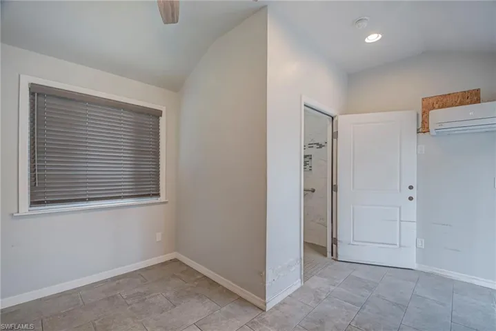 Spare room featuring vaulted ceiling, a wa