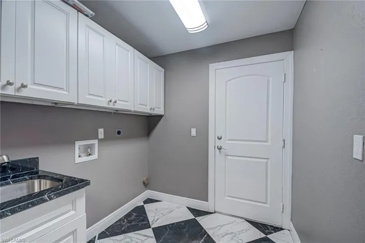 Laundry room with marble finish flooring, washer hookup, hookup for an electric dryer, and cabinet space