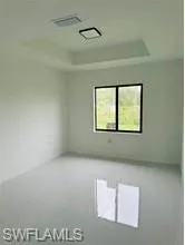 Tray ceiling with integrated lighting, recessed square light fixture, and tile flooring