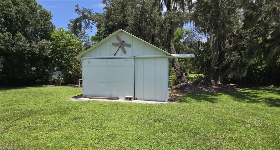 View of outdoor structure featuring a lawn