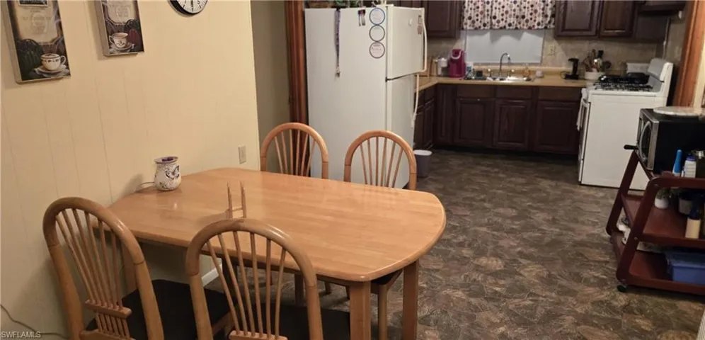 Dining space featuring sink and dark tile patterned flooring