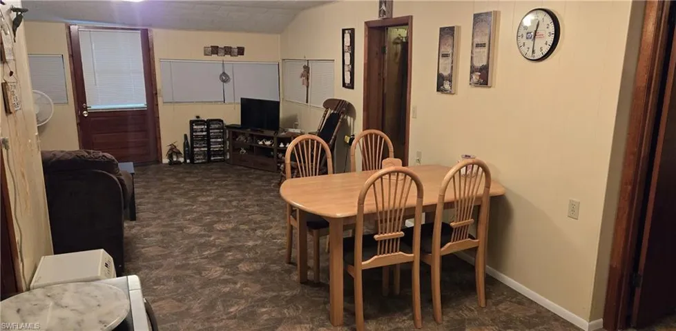Dining space featuring dark parquet flooring and vaulted ceiling