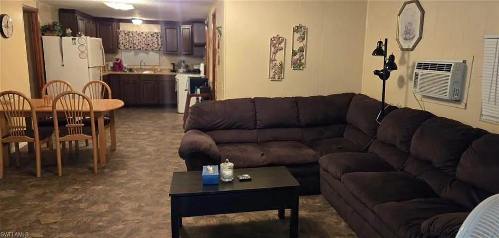 Living room with a wall mounted AC and sink