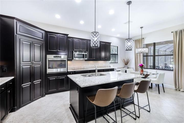 Rich Espresso cabinets are complemented by lighter counters and new lighting fixtures. Note the built in desk as well.