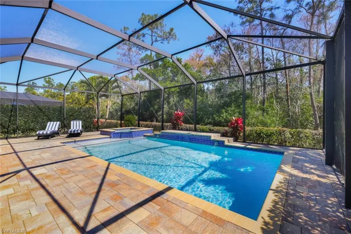 Enjoy relaxing outdoors on your spacious lanai with heated saltwater pool and spa surrounded by lush tropical protected preserve views.