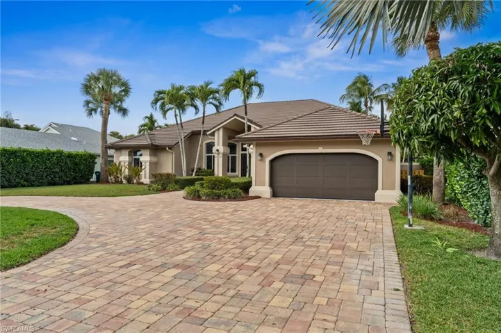 Ranch-style house with stucco siding, decorative driveway, a garage, a front yard, and a tile roof